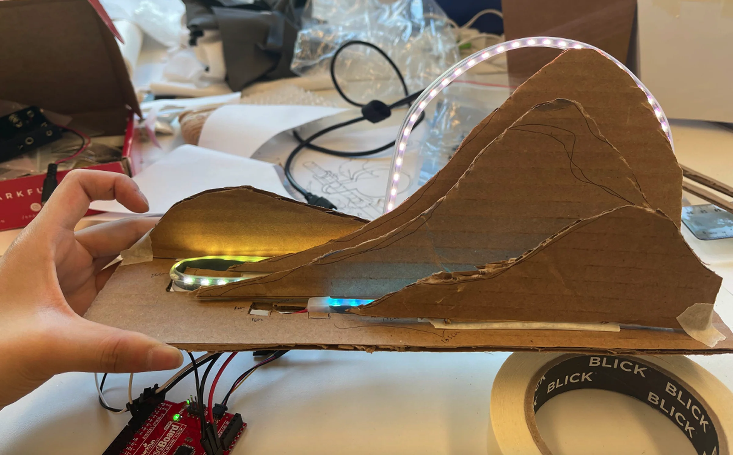 Cardboard landscape prototype — layered mountain profiles with LEDs threaded through