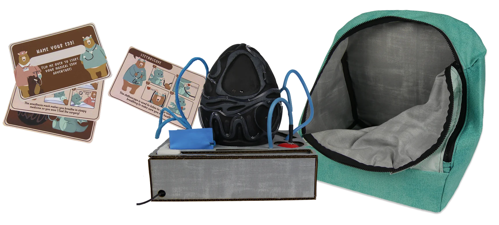 Full spread of all MedEgg kit components: egg, stethoscope, IV drip, anesthesia mask, cards, backpack